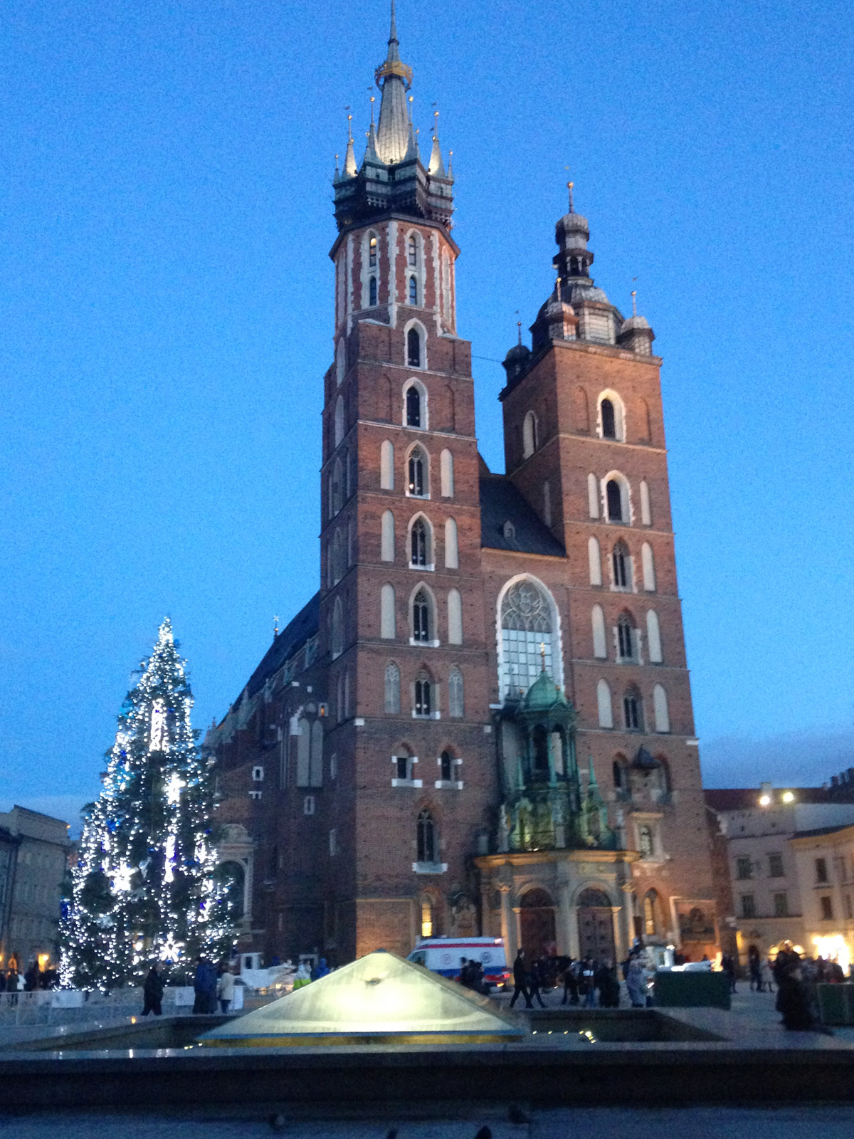St. Mary's Basilica at dusk beside a lit Christmas tree, Kraków