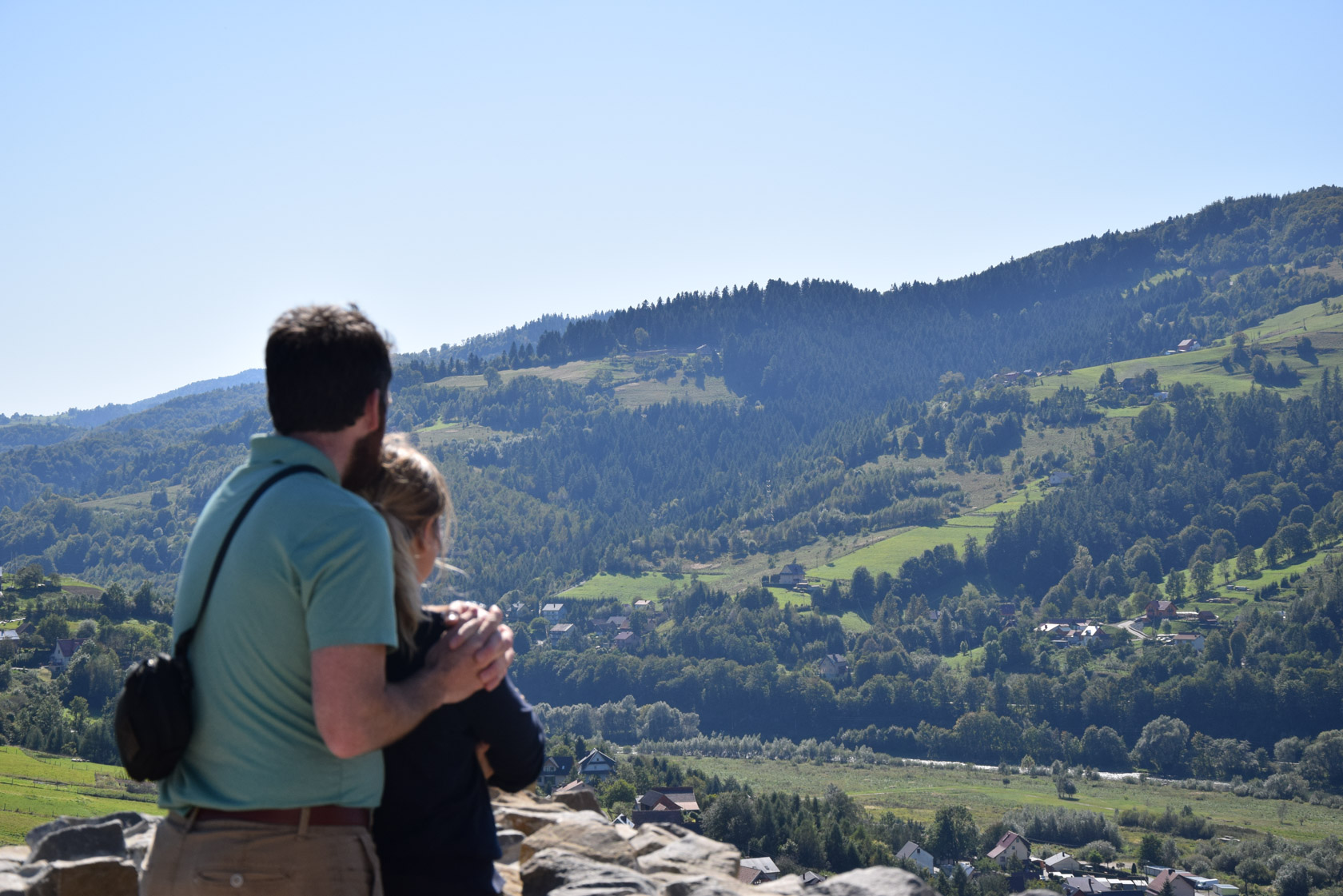 Peter and Erin overlooking a green mountain valley in southern Poland